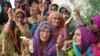 Women wait for relief aid near their damaged houses in the flood-affected town of Gandawah in the southwestern province of Balochistan on August 2. 