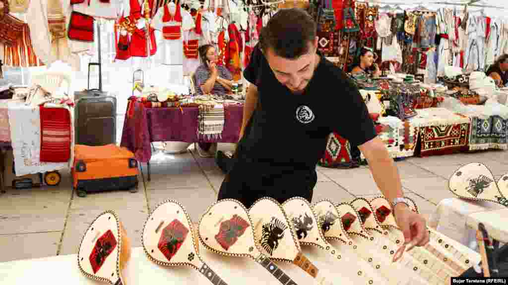 Një vizitor duke shikuar çiftelitë e zbukuruara me motive kombëtare.&nbsp;