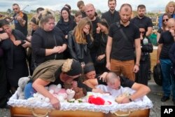 Artem Dmitriev plânge moartea fiicei sale Liza, fetița de 4 ani ucisă de ruși în Vinița, într-un atac cu rachete. Mama ei, Irina, se află în stare critică la spital. Alți doi băieți de 7 și 8 ani au fost uciși.