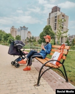A 2019-es fotón Irina egy dél-kijevi parkban pihen, miközben kislánya a babakocsiban alszik
