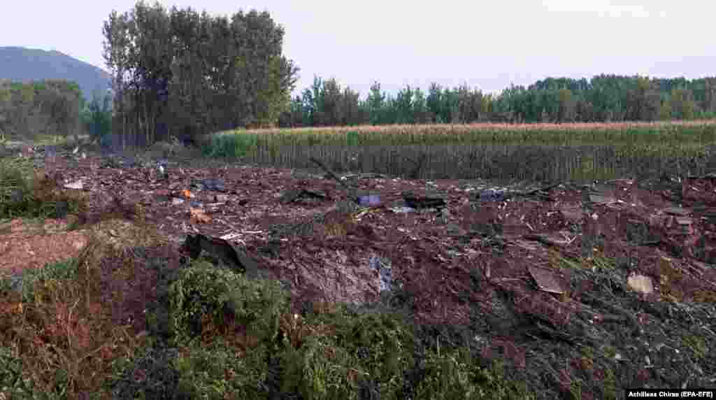 This view of the crash site on July 17 shows a mortar round (lower right) as well as what appears to be fragments of wooden ammunition boxes in the wreckage. Serbian Defense Minister Nebojsa Stefanovic said on July 17 that the plane was transporting 11.5 tons of Serbian munitions to Bangladesh and denied speculation that the cargo was destined for Ukraine. &nbsp;