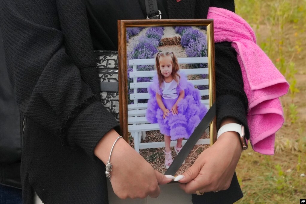 Një grua mban në duar fotografinë e Lizës 4-vjeçare, e cila u varros më 17 korrik në Vinicija.