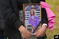 Një grua mban në duar fotografinë e Lizës 4-vjeçare, e cila u varros më 17 korrik në Vinicija.