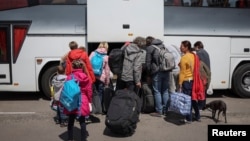 Ukrainian refugees from the Mariupol region board a bus bound for Poland in Zaporizhzhia, Ukraine.
