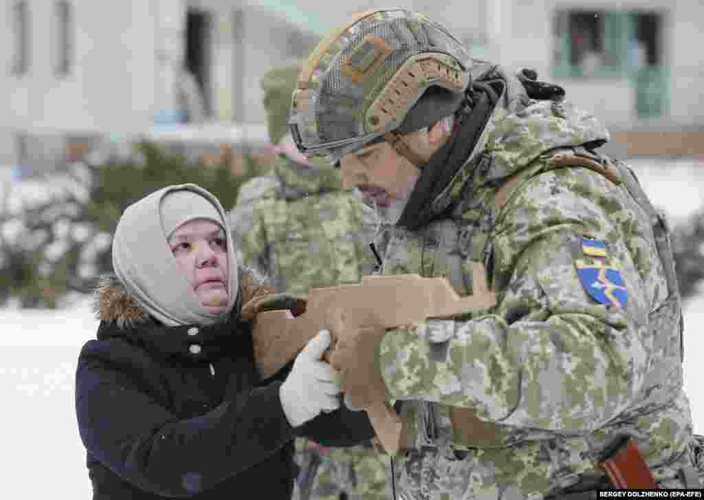 Rumia, 59-vjeçare nga Kievi i Ukrainës, përdor një pushkë prej druri teksa trajnohet që të përdorë armët, në kohën e rritjes së frikës për një pushtim rus. Rumia është tatare nga Krimea, gadishull që u aneksua nga Rusia më 2014.