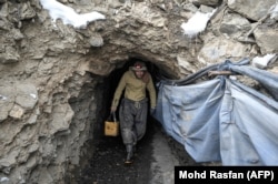 A miner emerges from a tunnel where explosives are used to break through the mountainside in the hunt for emeralds.