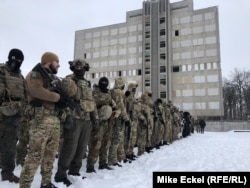 Кілька сотень людей – переважно чоловіків, багато в камуфляжі чи повністю чорному одязі – стояли на території покинутого заводу важкого машинобудування на західній околиці київської столиці