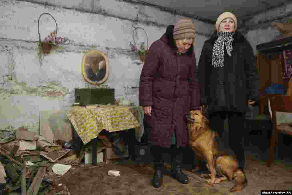 Liliya, left, and Tatyana, both residents of a village on the outskirts of Donetsk, speak to a journalist in a basement used as a bomb shelter on territory controlled by Russia-backed separatists not far from the front line with Ukrainian government forces. Liliya and five other people live in a five-story apartment building without heat or water.
