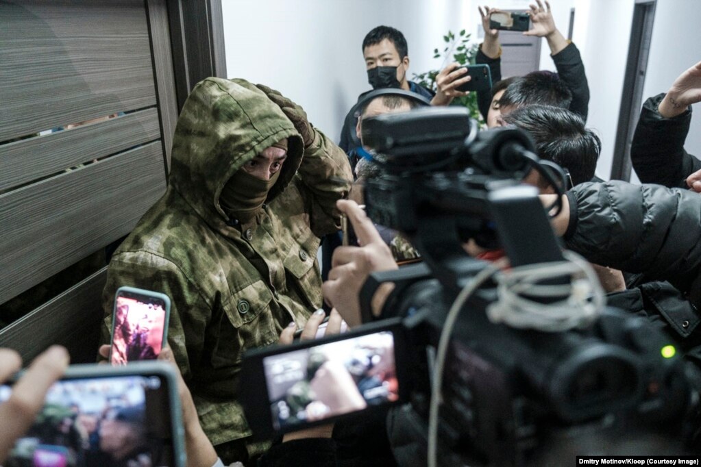 Novinari, advokat i pristalice su pojurile na mesto racije, ali ih je zaustavio čovek koji je imao zelenu fantomku na glavi.