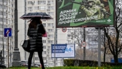 24 октября 2022 года в Москве пешеход проходит мимо плаката с изображением российских солдат и лозунгом "Армия России — армия профессионалов"