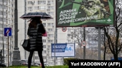 24 октября 2022 года в Москве пешеход проходит мимо плаката с изображением российских солдат и лозунгом "Армия России — армия профессионалов"