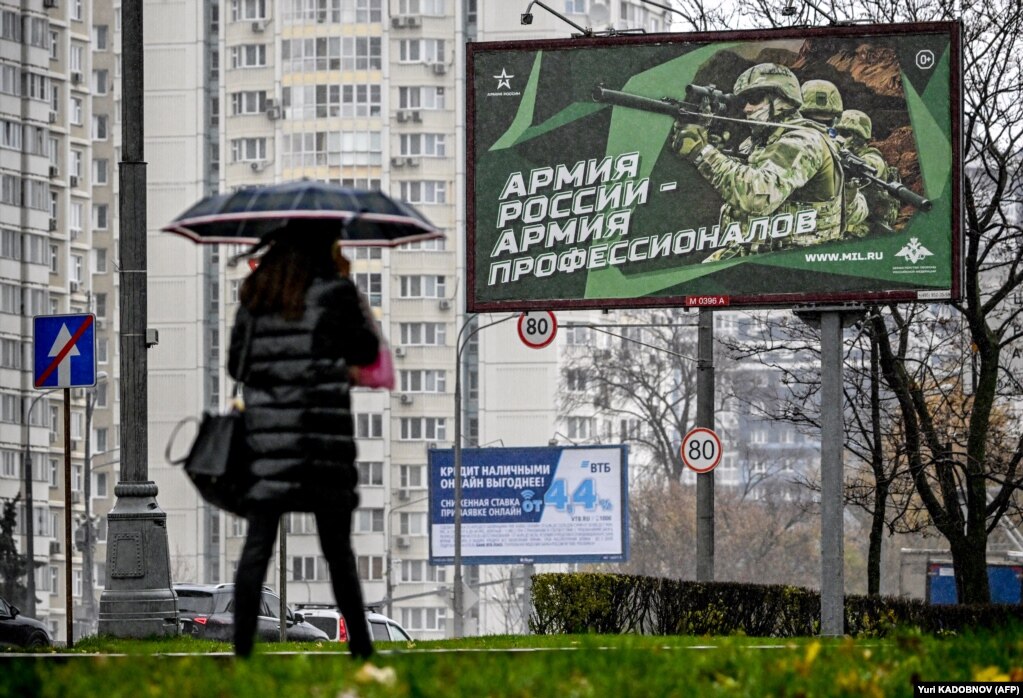 Një këmbësore kalon pranë një billbordi në një nga rrugët e Moskës - ku shihen ushtarë rusë dhe në slogan thuhet: "Ushtria e Rusisë - Ushtria e Profesionistëve".