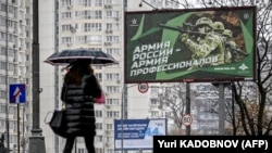 Пешеход проходит мимо пропагандистского плаката с изображением российских солдат. Москва, 24 октября 2022 года