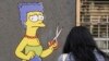  Prolaznica fotografiše mural pod nazivom "Rez" uličnog umetnika AleXandra Palomba koji prikazuje Marge Simpson, lik animirane televizijske serije "Simpsonovi" kako šiša svoju kultnu kosu, ispred konzulata Irana, u Milanu, Italija, 5. oktobar 2022.