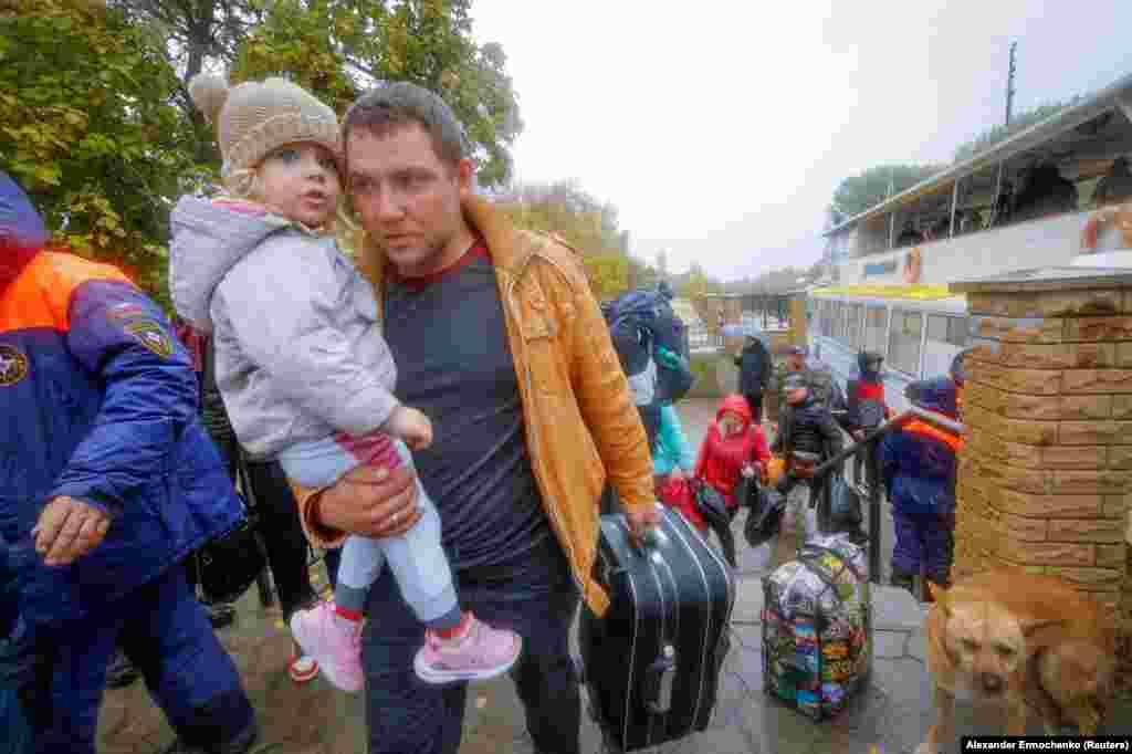 23 octombrie: zi ploioasă în Oleșki, regiunea ucraineană Herson, Civilii coboară de pe feribot și se îndreaptă spre autobuzul care îi va duce în Crimeea ocupată de Rusia. &nbsp;