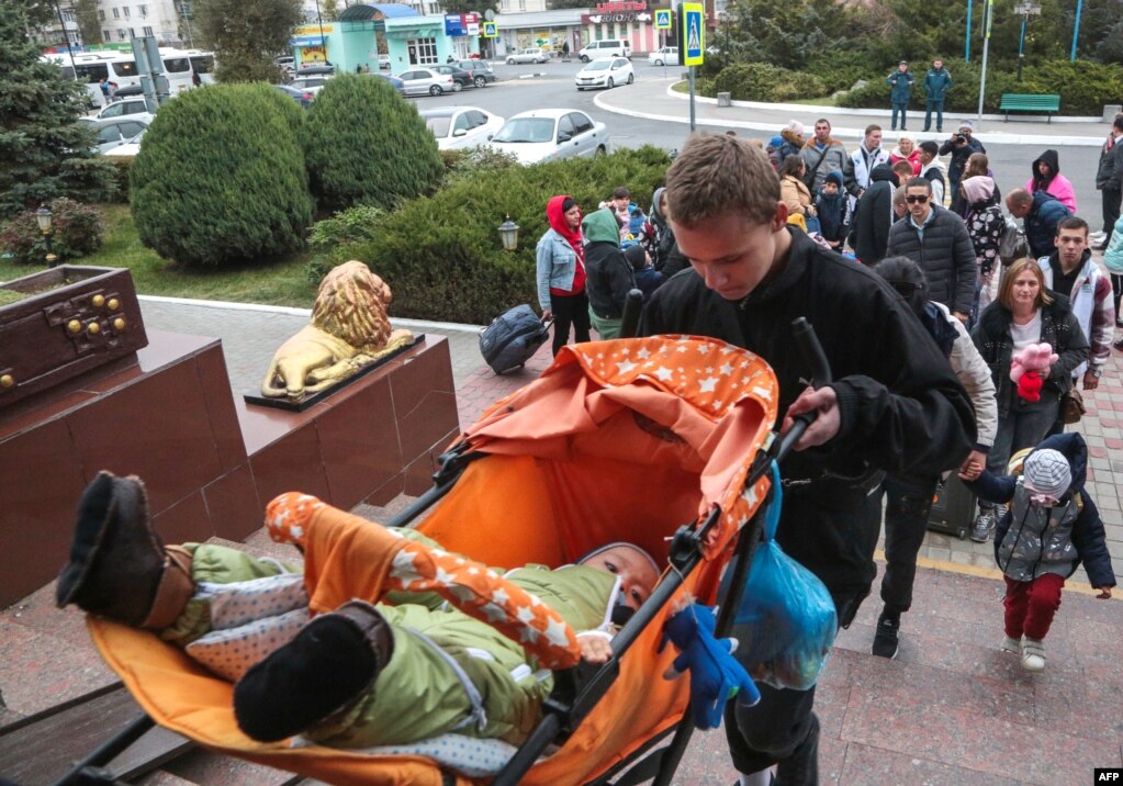 Një burrë duke bartur një bebe në një karrocë nëpër shkallët e stacionit të trenave Dzhankoi, në Krime, më 21 tetor. Rreth 25.000 njerëz janë larguar nga rajoni që nga 18 tetori, sipas agjencisë ruse të lajmeve Interfax.