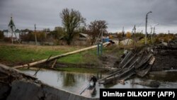 Человек несет воду через разрушенный мост в Бахмуте, Донецкая область, Украина. 27 октября 2022 года.
