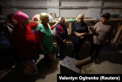 Местные жители укрылись в бомбоубежище в селе Лупарево недалеко от линии фронта в Николаевской области, 18 октября 2022 года