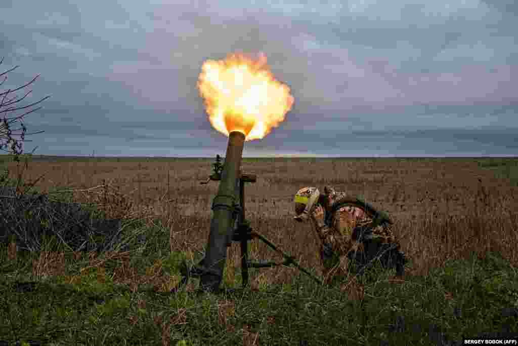 A member of the Ukrainian National Guard fires a mortar along the front line in Ukraine&#39;s conflict with Russian invaders in the Kharkiv region.