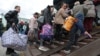 Вывезенные из оккупированной Россией Херсонской области Украины люди прибывают на железнодорожную станцию в Джанкое, городе на севере аннексированного Россией Крыма. 20 октября 2022 года