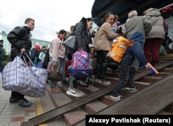 Гражданские лица, эвакуированные из подконтрольной России Херсонской области Украины, прибывают на железнодорожную станцию в городе Джанкой, Крым, 20 октября 2022 года