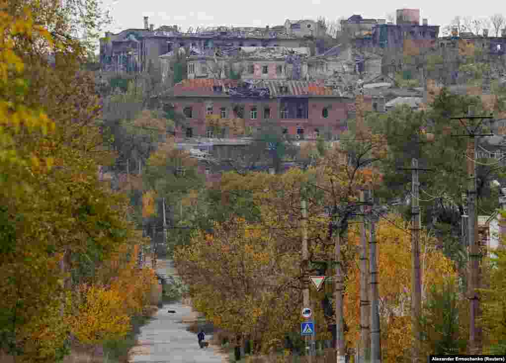 Човек влече количка кон уништеното предградие на Мариупол на 29 октомври.