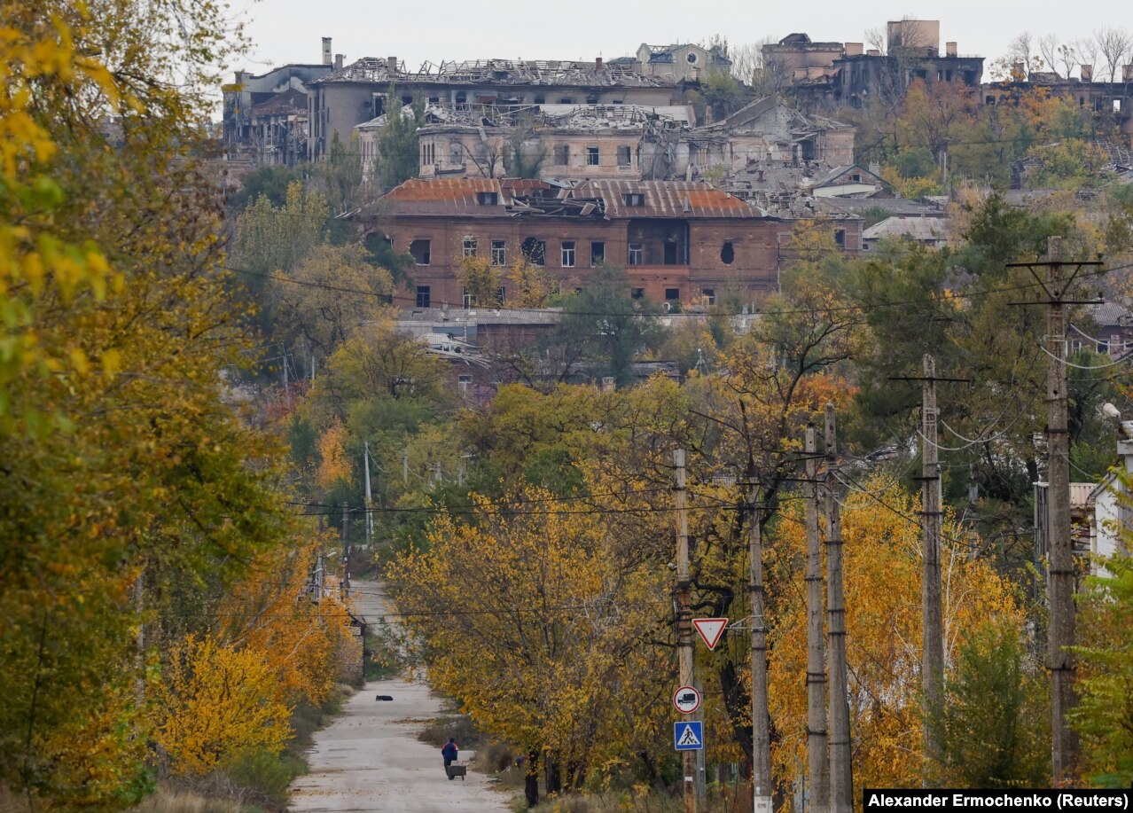 A man pulls a cart toward a destroyed suburb of Mariupol on October 29.