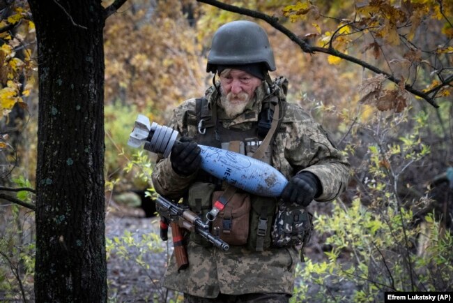 A Ukrainian soldier carries a shell with a written message to the Russian Army at a frontline position near Bakhmut on October 27.