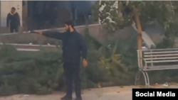 تصویر یکی از نیروهای بسیجی که در اعتراضات دانشجویان دانشگاه آزاد تهران شمال اقدام به شلیک با کلت می‌کند