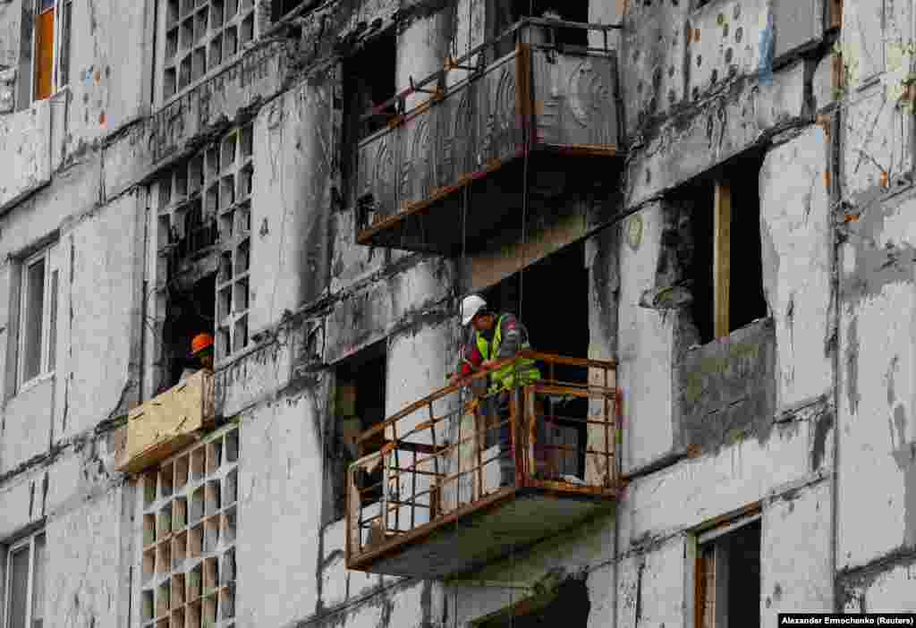 Градежни работници во станбена зграда оштетена од војна. Сликите од разурнатиот град станаа симбол на руската разорна инвазија врз Украина, но во последните месеци само повремено фотографии беа објавени од руските државни новински агенции.