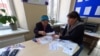 O femei este ajutată de asistenta socială să se înregistreze pentru a putea beneficia de compensație pentru perioada de iarnă. Fotografie din 2022. 