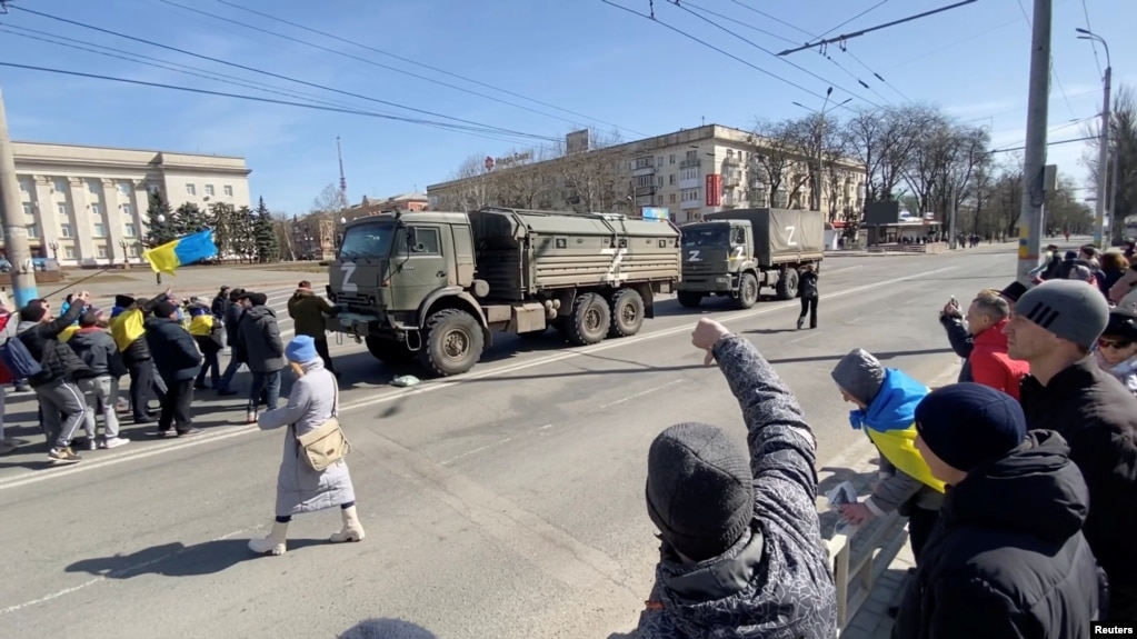 Demonstruesit pro-Ukrainës duke u ballafaquar me një kolonë ushtarake ruse në Herson, në mars. Qyteti jugor u bë simbol i kundërshtimit në fillim të pushtimit, teksa banorët rrezikuan jetën e tyre për të protestuar kundër okupimit rus.