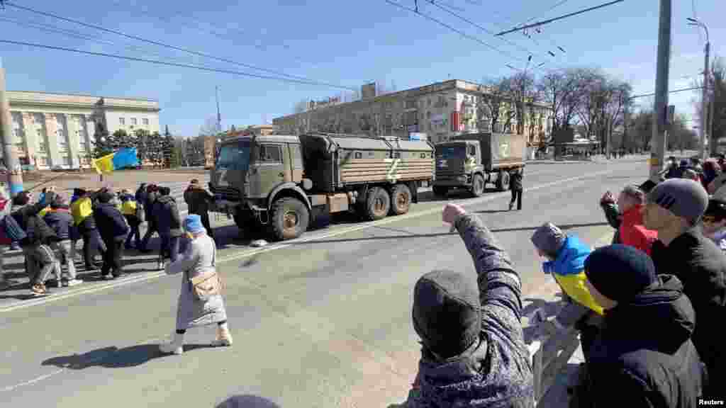 Manifestanți pro-ucraineni înfruntă un convoi militar rusesc în Herson, în martie. Orașul din sudul țării a devenit un simbol al sfidării încă de la începutul invaziei, deoarece locuitorii și-au riscat viața pentru a protesta împotriva ocupației rusești.