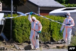 Oficerët e Policisë mjekoligjore inspektojnë vendin e aksidentit.