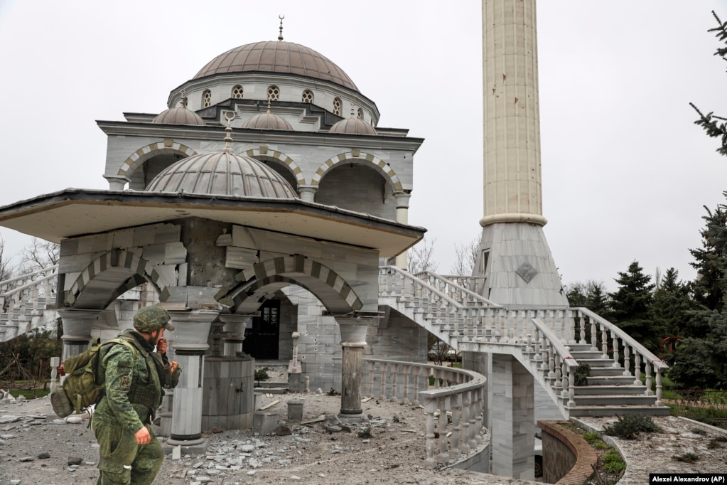 Një ushtar rus kalon pranë Xhamisë së dëmtuar nga luftimet në prill të këtij viti .