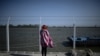 Жінка-біженка дивиться в бік України після перетину кордону з Румунією, 14 квітня 2022 року