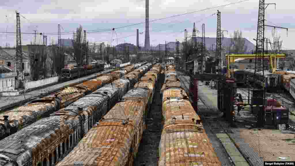 Burned-out trains on the same coastal track photographed in 2022. The slagheap in the background is on the site of the Azovstal factory.&nbsp;