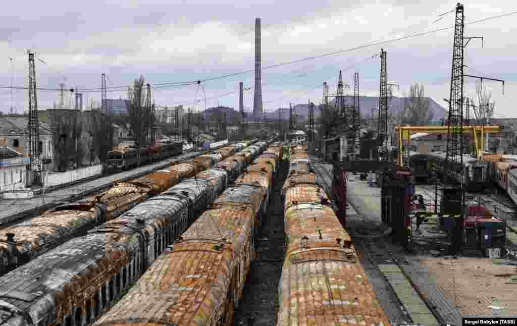 Burned-out trains on the same coastal track photographed in 2022. The slagheap in the background is on the site of the Azovstal factory.&nbsp;