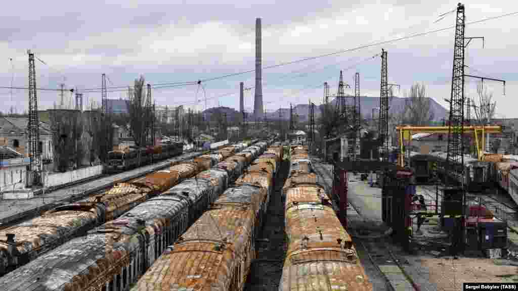 Burned-out trains on the same coastal track photographed in 2022. The slagheap in the background is on the site of the Azovstal factory.&nbsp;