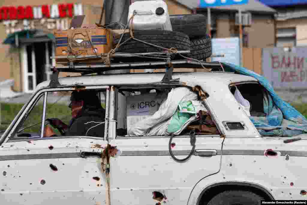 A man transports his belongings in a heavily damaged car in Mariupol on May 3.