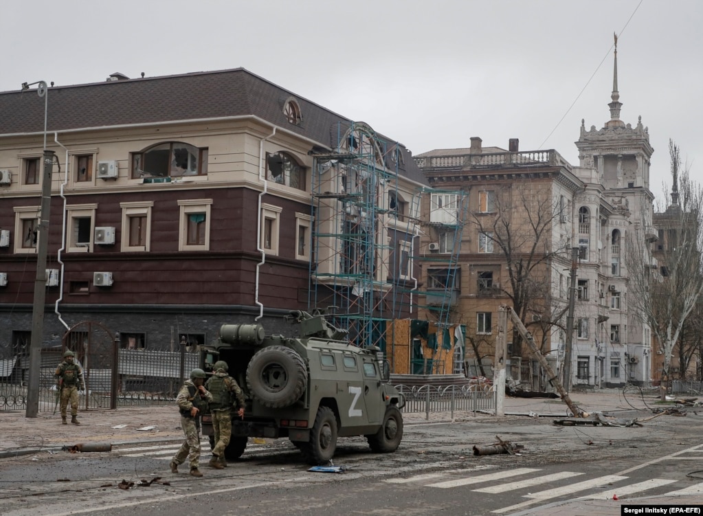Trupat ruse shihen duke dalë nga një automjet i blinduar pranë "shtëpisë me majë" të epokës staliniste në prill të këtij viti.