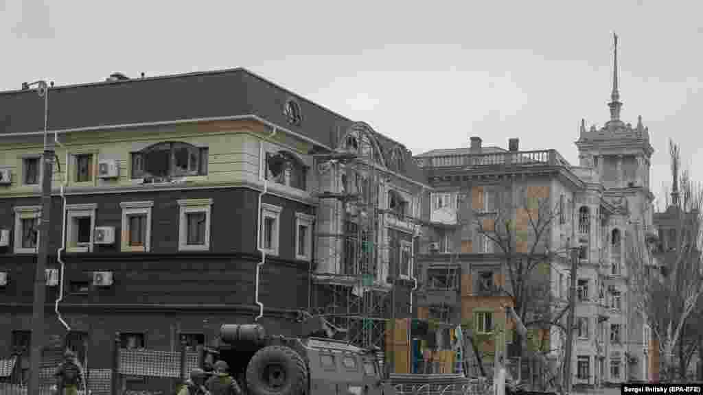 Russian troops unloading an armored vehicle near the Stalinist-era spire house in April 2022.&nbsp;
