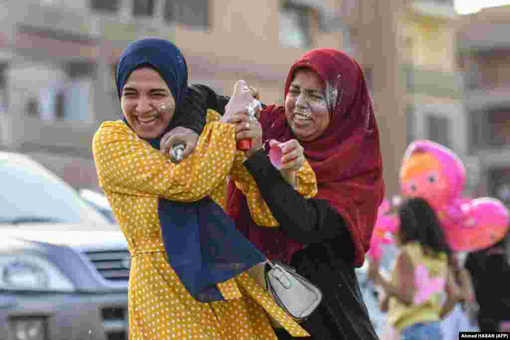 Egyptian Muslim women spray foam on each other after prayers on the first day of Eid al-Fitr in Cairo on May 2.