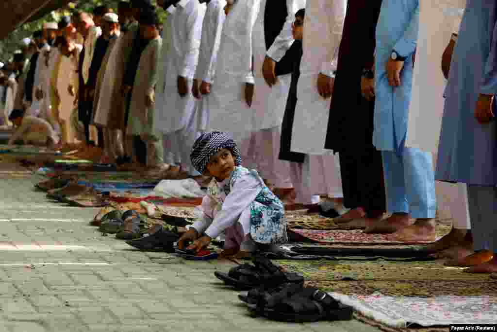 A young Pakistani boy plays with sandals during the Eid al-Fitr prayers in Peshawar on May 2.