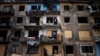 Local residents close the windows of an apartment building with plywood, Dobropillya, Donetsk, April 30, 2022 (AP Photo/Evgeniy Maloletka)