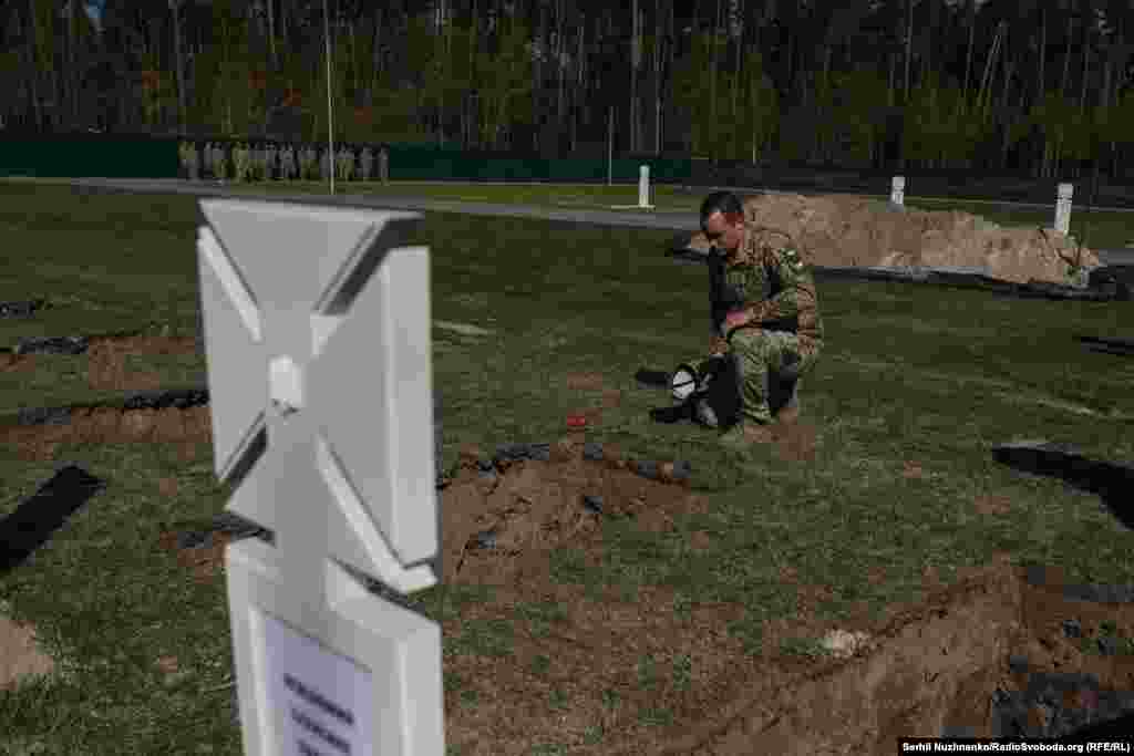 Військовий віддає шану загиблому захиснику України
