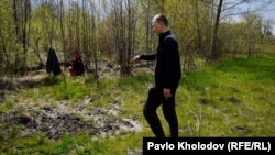 Денис Зосименко ‒ колишній полонений, якого утримували російські військові, показує місце, де була могила вбитого чоловіка