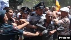 Police clash with protesters after they tried to enter a government building in Yerevan on May 30.