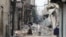 Syria -- Civilians walk past debris from destroyed buildings in the old sector of the northern city of Aleppo, 23Oct2012