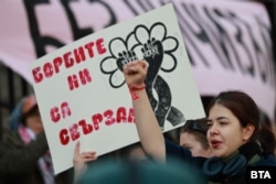 Плакат с надпис „Борбите ни са свързани“ по време на протеста пред Съдебната палата, 8 март 2026 г.